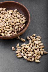 pistachios in a plate on a black background
