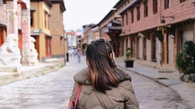 Young woman traveler walking in the old town, Shangri-la and taking a picture, Travel concept