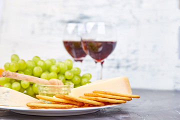 Cheese plate variety, and wine in glasses