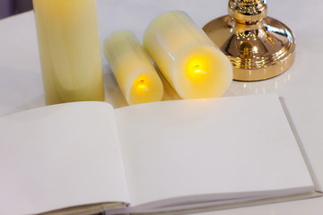 Wedding signing book, blank page, guest list, with candles and gold  candlestick. concept by memory and notebook.Notepad book.Notebook and white background