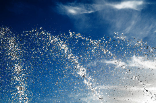 Drops of water from a fountain on a background of blue sky