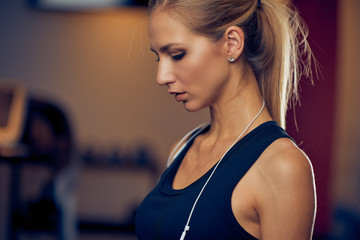 Close up of woman looking down. Gym interier. Healthy lifestyle concept.