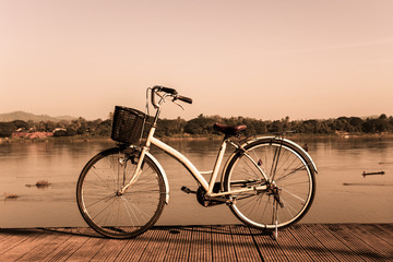 Bicycle near lake during sunset.Vintage bike near the lake in the evening, warm sunset view.