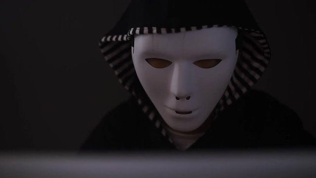 Masked Hacker is Using Computer