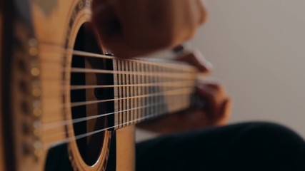 Close up shot of guitarist's hands plays chords on acoustic guitar at home - Powered by Adobe