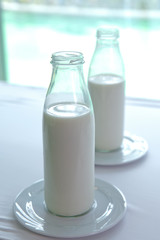Bottles of milk on wooden table . Delicious fresh milk, one of the primary sources of nutrition.