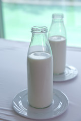 Bottles of milk on wooden table . Delicious fresh milk, one of the primary sources of nutrition.