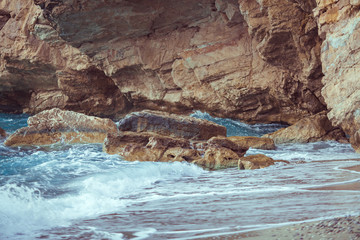 Wave spray splash over beach at blue sea