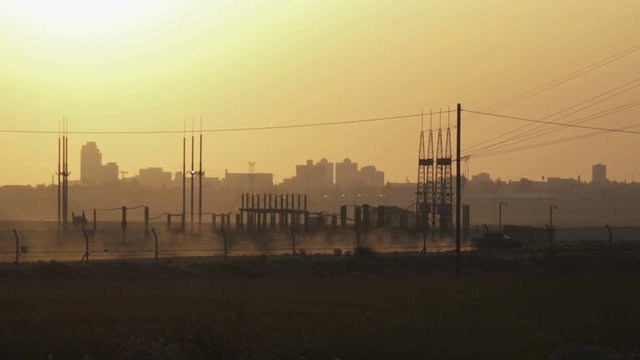 Sunrise with view to city Beer Sheva in  Israel and Pickup car cross board gate. Buildings on the background.
