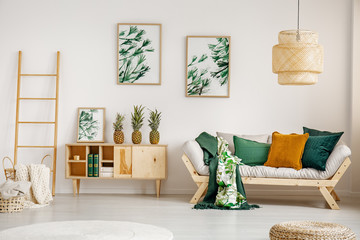Elegant living room with wooden furniture and green graphics on the wall, real photo