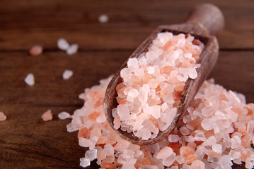Fototapeta na wymiar Pink salt in a scoop on a wooden background.