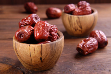 Dry Chinese dates unabi in a bowl on a wooden background.