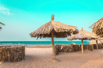 Fototapeta na wymiar beach umbrellas made from natural materials by the sea
