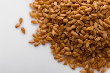 Seeds of golden flax on a white background