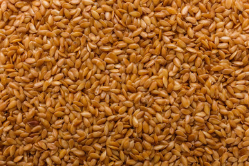 Seeds of golden flax on a white background