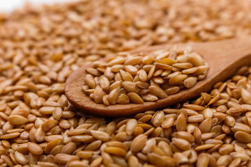 Seeds of golden flax on a white background