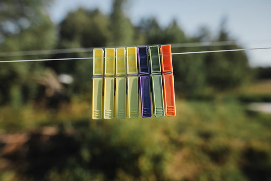 Row of clothes pegs hanging side by side on washing line