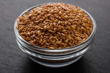 seeds of golden flax on a dark stone background