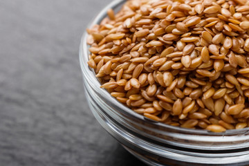 seeds of golden flax on a dark stone background