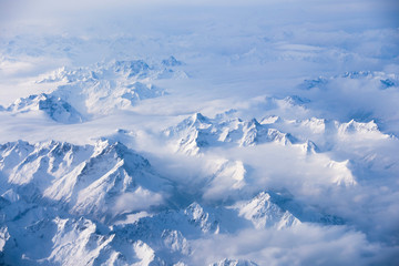 Fototapeta premium winter mountains in the clouds from aircraft