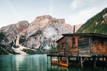 Panoramic view of Braies Lake with the hut and boats in Dolomites mountains and Seekofel in the morning, Pragser Wildsee, South Tirol, Italy