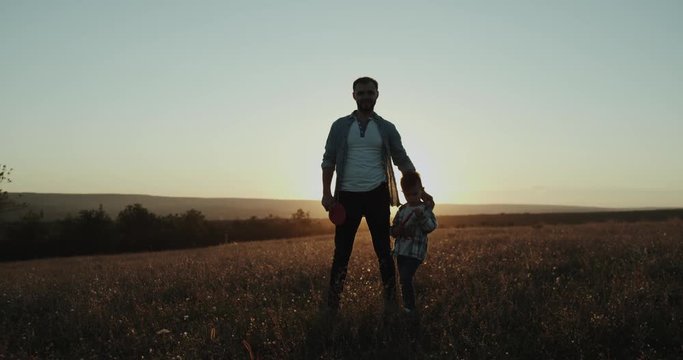 Dad teaching his son , at sunset , playing with a small tennis racquet and a ball , amazing view. shot on red epic . 4k