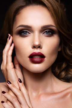 Close-up portrait of beautiful woman with bright make-up and dark red lips