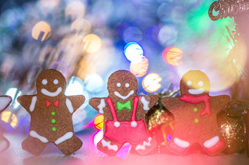 Cute gingerbread man with christmas tree and blurry sparkle background, close up, bokeh, text space(copy space)