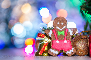 Obraz na płótnie Canvas Cute gingerbread man with christmas tree and blurry sparkle background, close up, bokeh, text space(copy space)