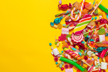 Fototapeta na wymiar colored candies on yellow background