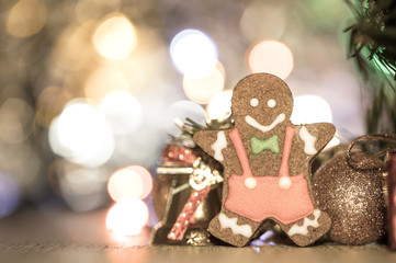 Cute gingerbread man with christmas tree and blurry sparkle background, close up, bokeh, text space(copy space)