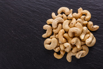 cashew nuts on a dark stone background