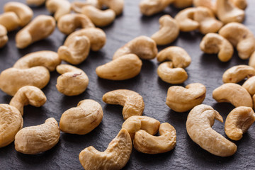 cashew nuts on a dark stone background