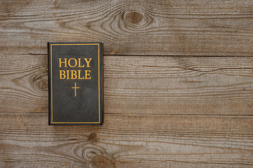 Obraz premium top view of holy bible on rustic wooden table