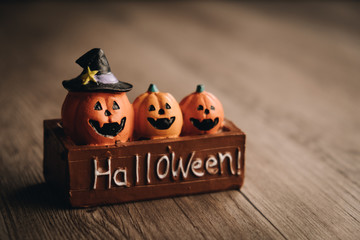 Three halloween pumpkins on fence with wooden background, Celebration theme, copy space for text.