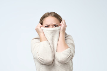 Woman being childish disappearing in her clothes looking from underneath. She is frightened with exam results.