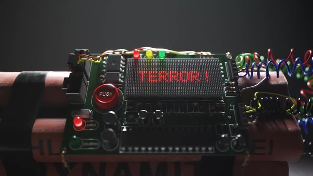 Armed TNT bomb isolated in dark room in spotlight. Terror word on a display.