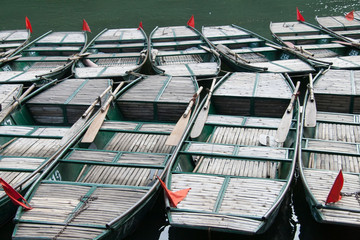 A group of wooden boats tied at the river edge