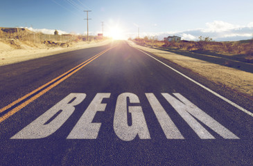 new start, travel and adventure concept - close up of word begin on suburban asphalt road