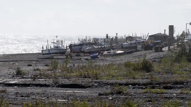 la spiaggia in autunno con un forte vento e imbarcazioni a secco