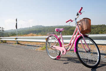 Fototapeta premium pink bicycle standing on the street and wood basket mountain background spring season good healthy activity holiday