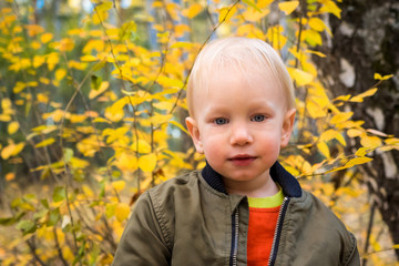 Portrait of happy smiling child playing having fun in warm autumn day.