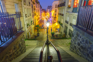 Typical Montmartre staircase with old street lamp and entrance to Paris Metro subway during evening blue hour in Paris, France