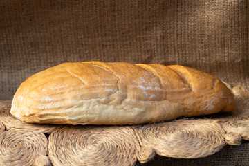 loaf of wheat bread on the background of burlap