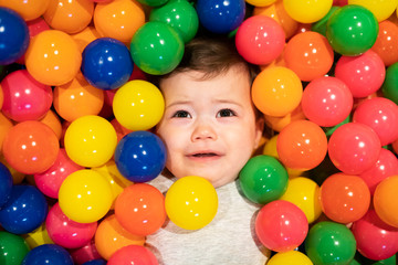 Fototapeta na wymiar Portrait of a adorable infant on colorful balls dont have fun