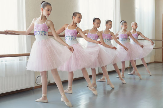 Group of young ballerinas practicing dance at classical ballet school