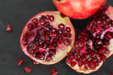 food, fruits and healthy eating concept - close up of pomegranate on stone table