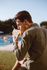 Man drinking cocktail near the pool