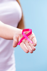 Woman with breast cancer awareness ribbon on hand