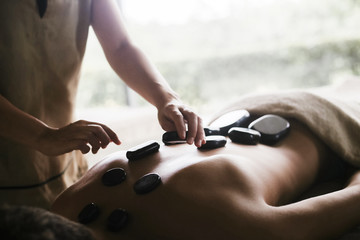 Back massage with oil and hot stones